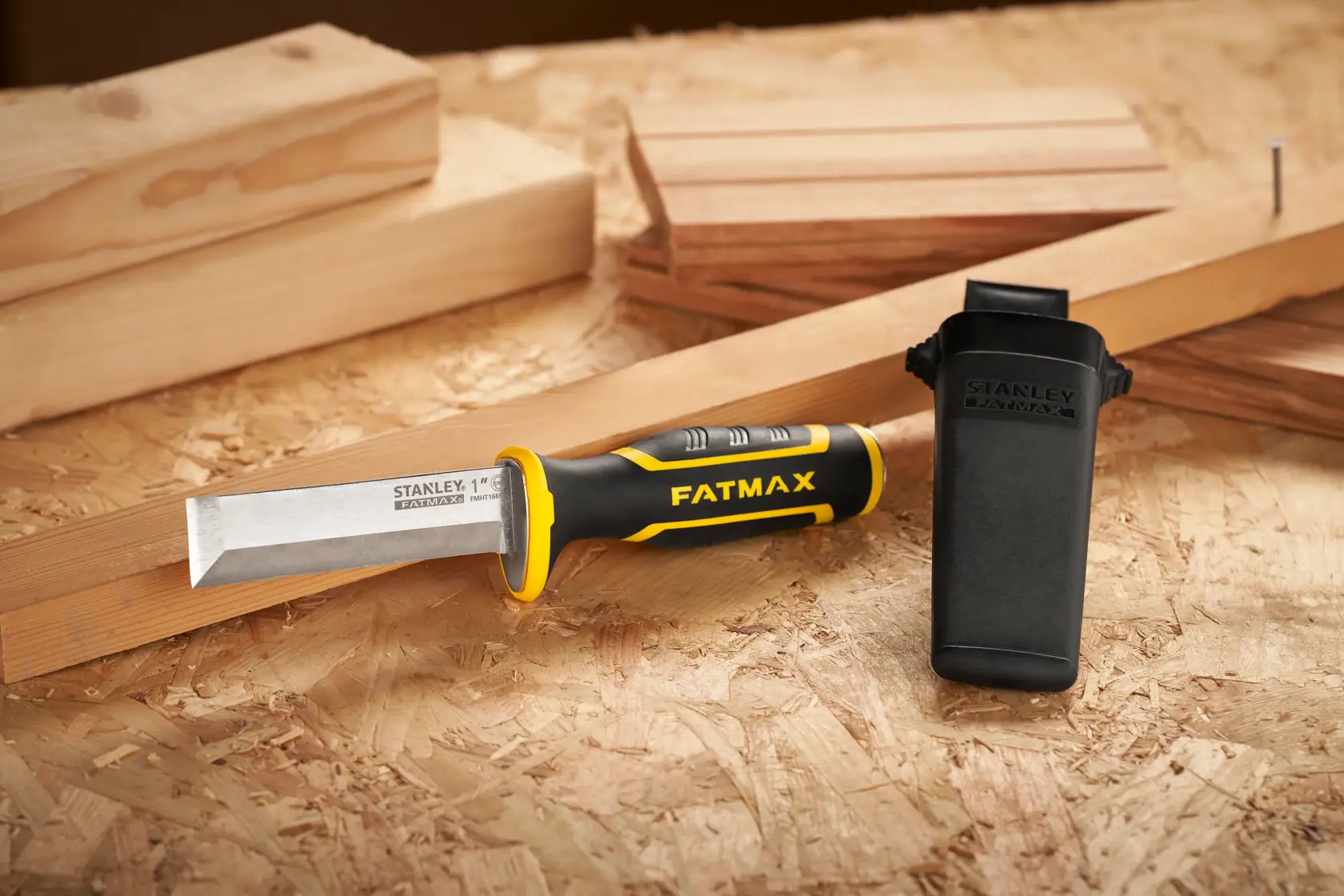 STANLEY FMHT16693-0 cincel con mango negro y amarillo y funda protectora sobre superficie de madera.