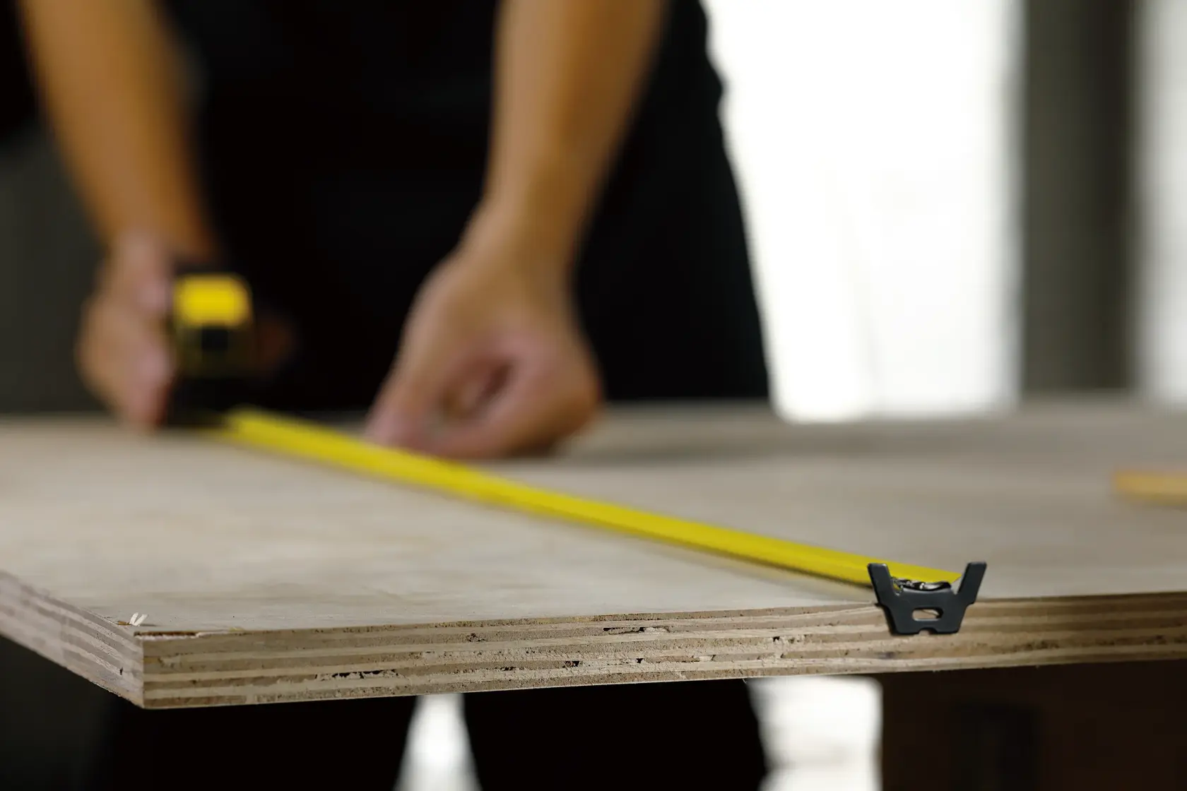 Fotografía de cinta métrica STANLEY 30-626 midiendo tablero de madera en taller
