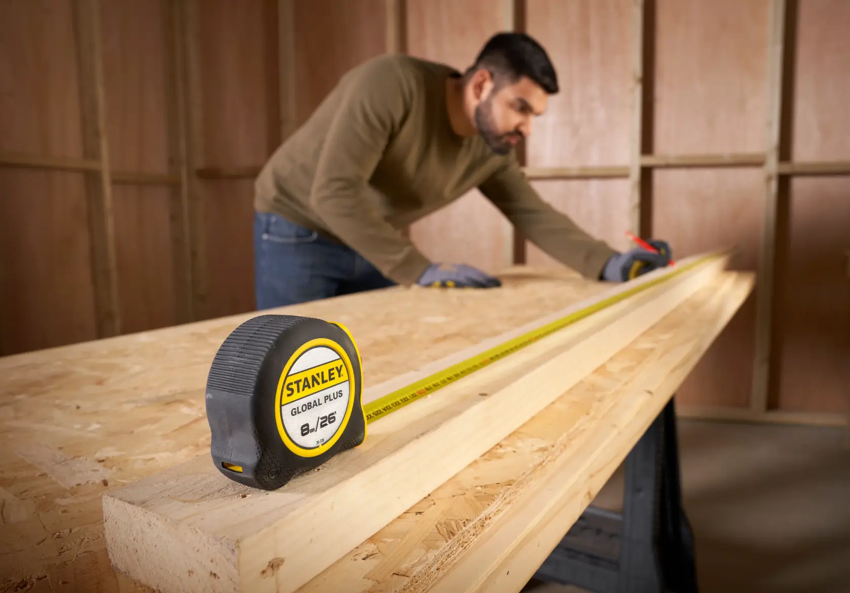 Cinta métrica STANLEY 30-726 sobre una tabla de madera, carpintero midiendo madera en taller.