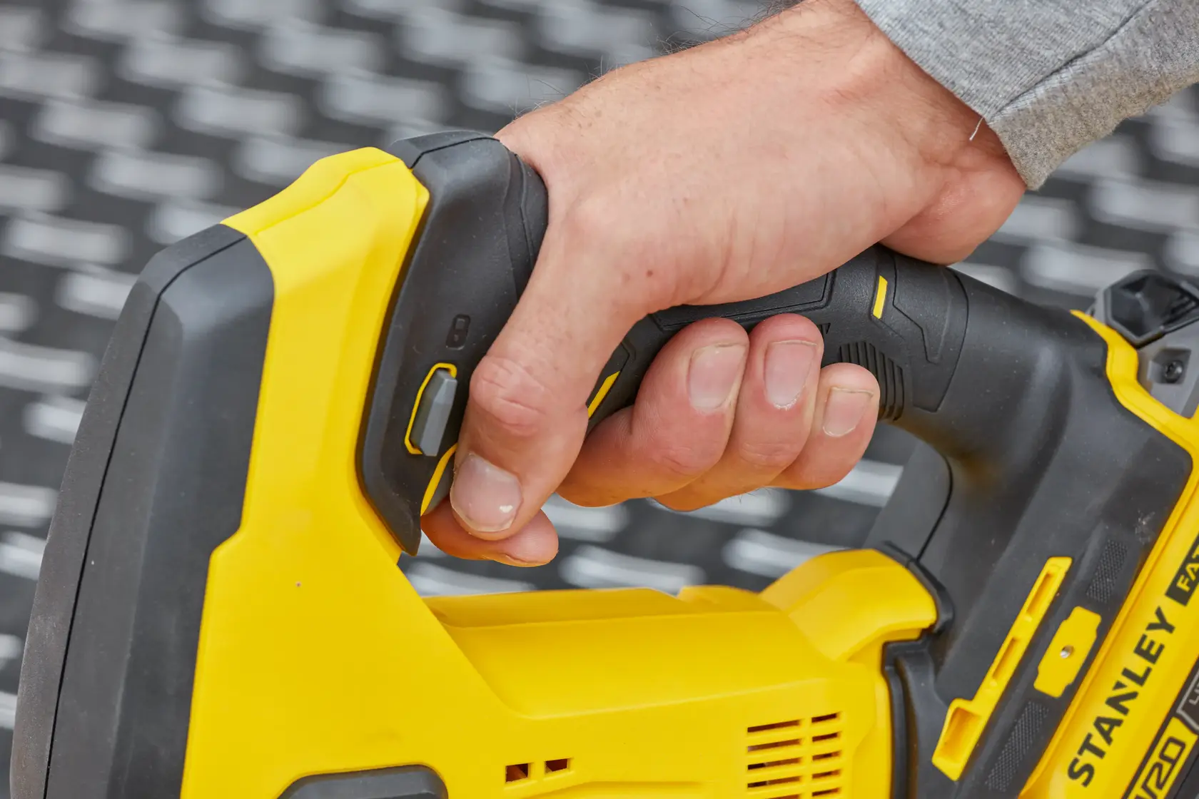 Fotografía del mango ergonómico amarillo y negro de la STANLEY SCJ600B en uso.